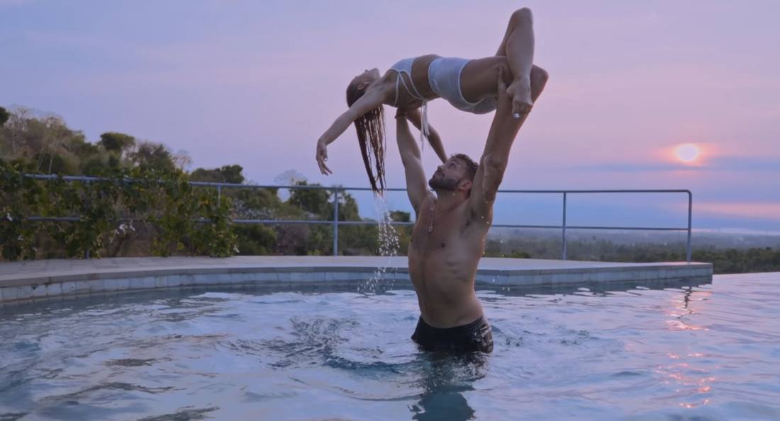 Pip lifted above a pool at sunset in the acro film with AcroJames
